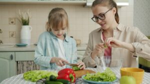 Mother and daughter preparing salad in the kitchen.
